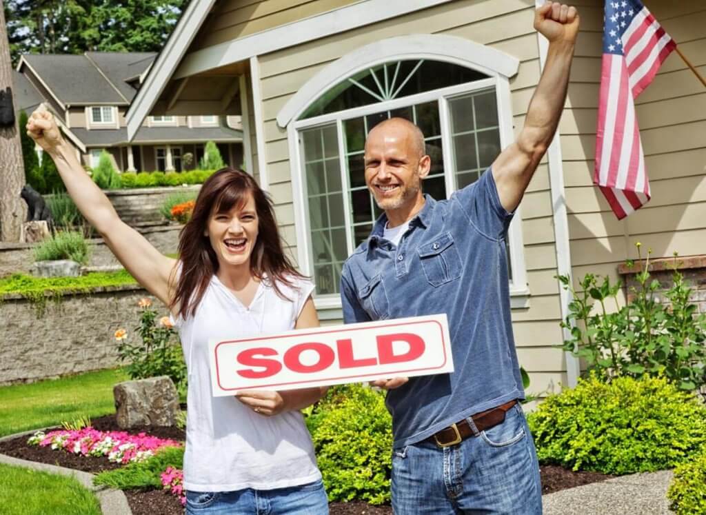 Couple in front of sold home