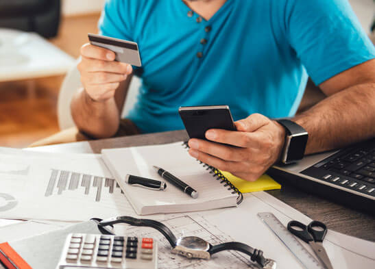 man with credit card and calculator