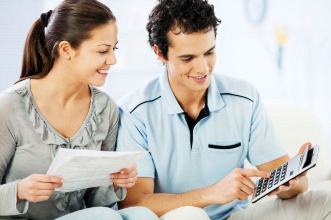 how to build credit; young woman looking at papers, young man with calculator