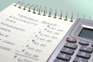 how to live debt free; calculator and notepad with budget written on it