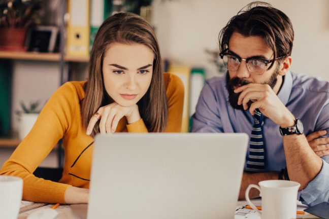 Couple sits at a laptop to focus on financial planning