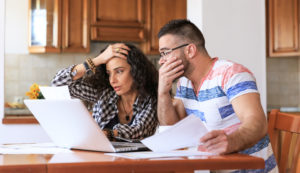 loans to family members; couple at kitchen table with bills looking stressed