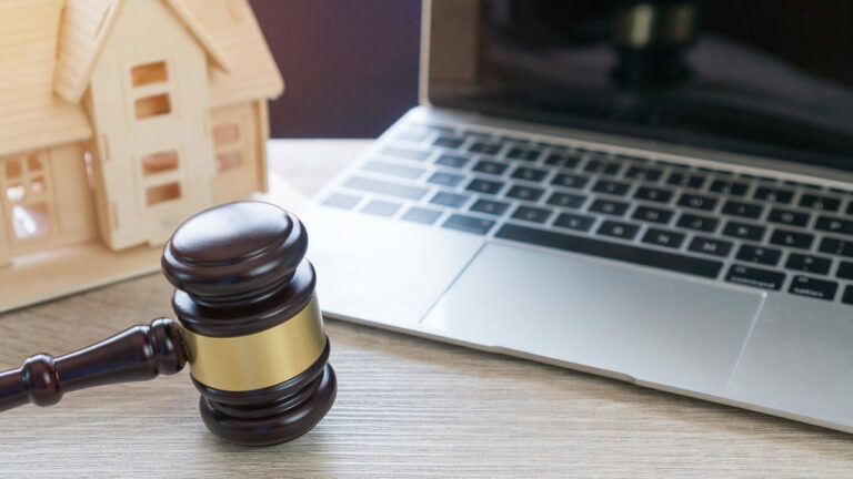 debt and divorce; computer, gavel, and mini house on a table