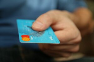 can i keep credit card reward points in after i consolidate my debt; person holding out blue credit card