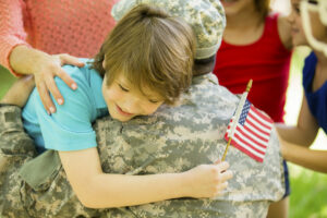 military identity theft; Service Member hugging a child holding an American flag