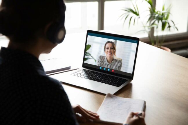 recession guide for grads; recent graduate doing a virtual job interview during the COVID-19 pandemic