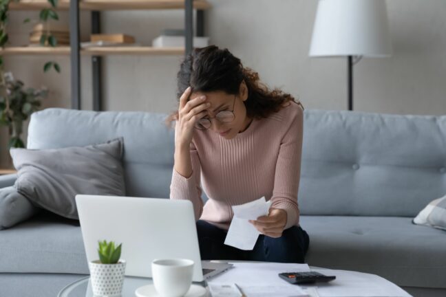 unexpected life events; worried woman reviewing bills