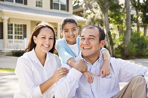 Hispanic family in front of their home