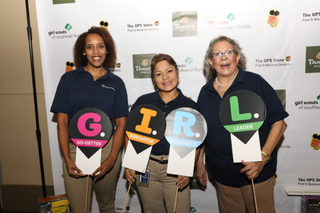 Group of women holding sign letters spelling out a word at an event